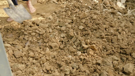 Un-Hombre-Asiático-Recolecta-Tierra-Y-Arcilla-Descalzo,-Revelando-El-Proceso-Tradicional-De-Obtención-De-Materiales-Para-La-Fabricación-De-Cerámica