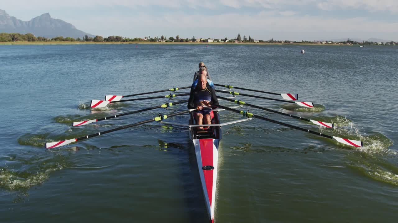 Four senior caucasian men and women rowing boat on a river