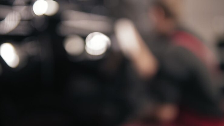 Blurred, at fisrt unfocused footage of automechanic wiping car's surface with microfiber.