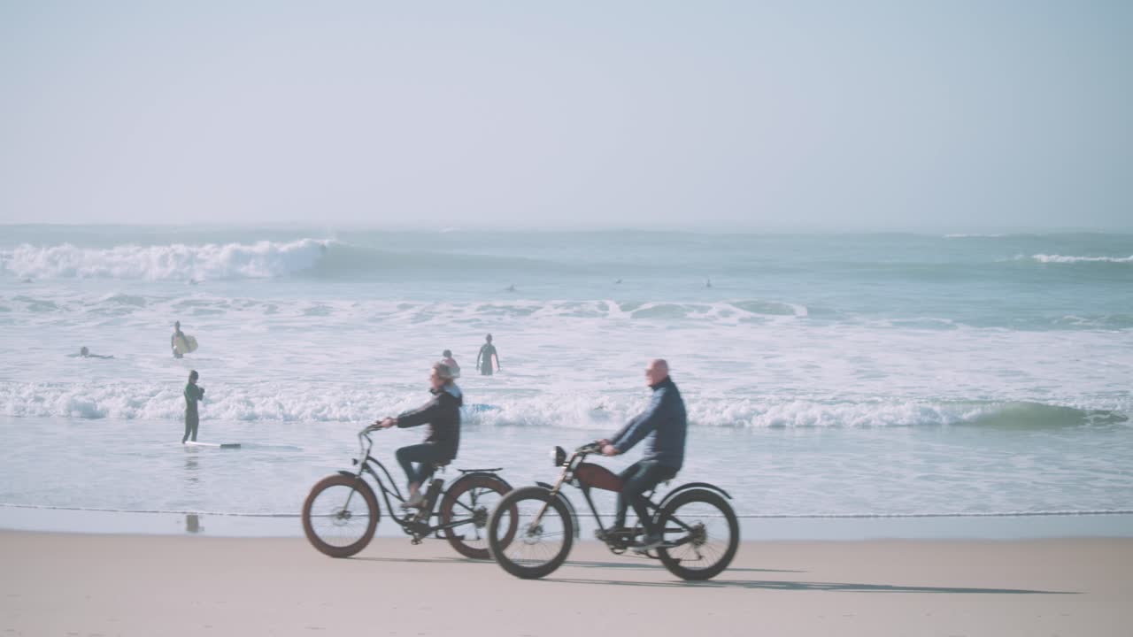 Couple riding bikes at the beach