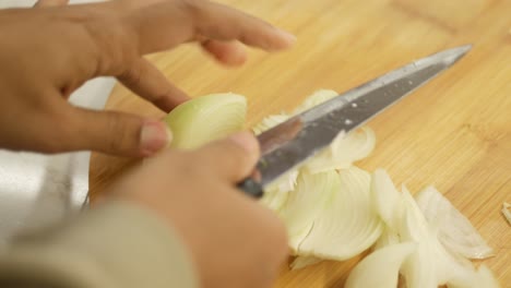 woman cutting onion on wooden board