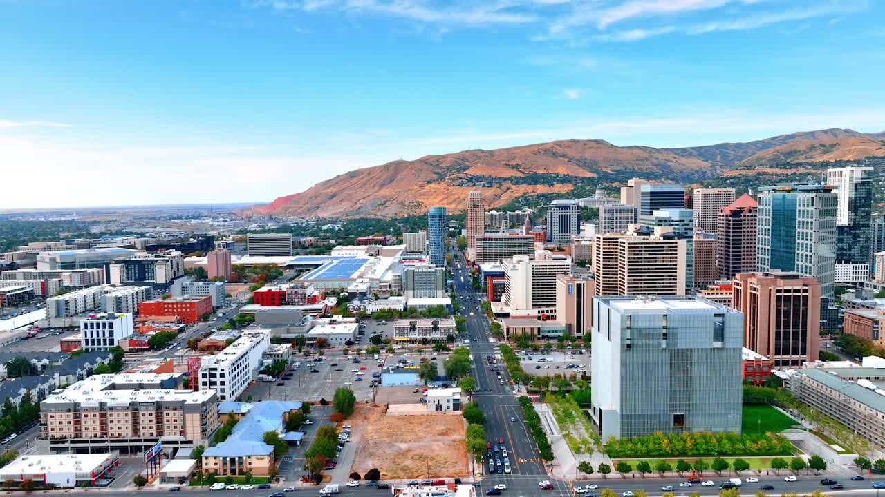 Salt Lake City, USA, 14 August 2025: Numerous cars in the traffic of the modern city. Flight above the wide-lane highway of Salt Lake City leading to the rocks at backdrop. Utah, USA