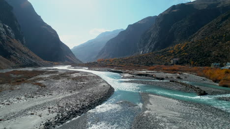 Beautiful-aqua-color-river-stream-flowing-under-highly-majestic,-rocky-mountain-landscape