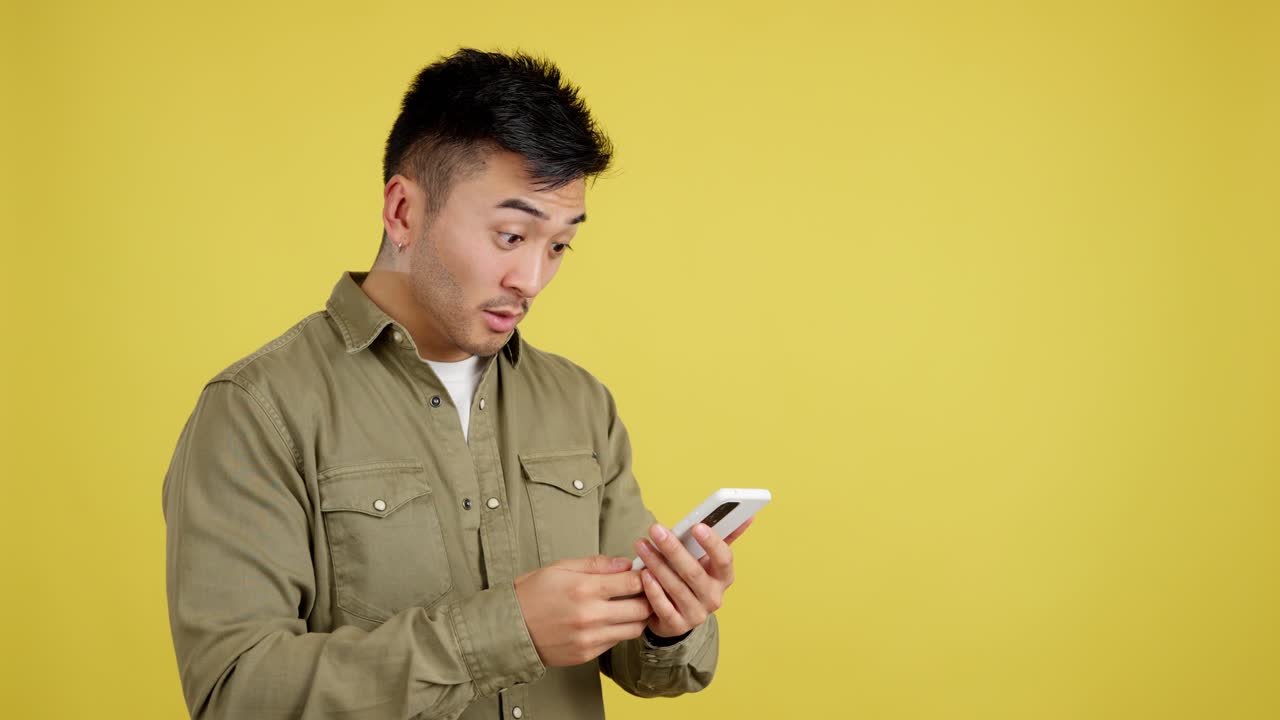 Asian man reacting to content on his smartphone