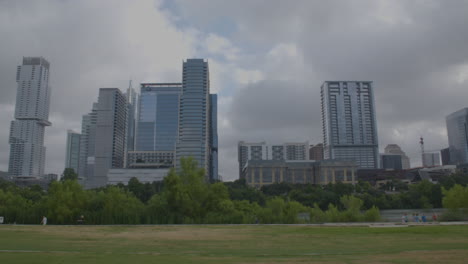 locked off shot of austin, texas skyline with people walking in background