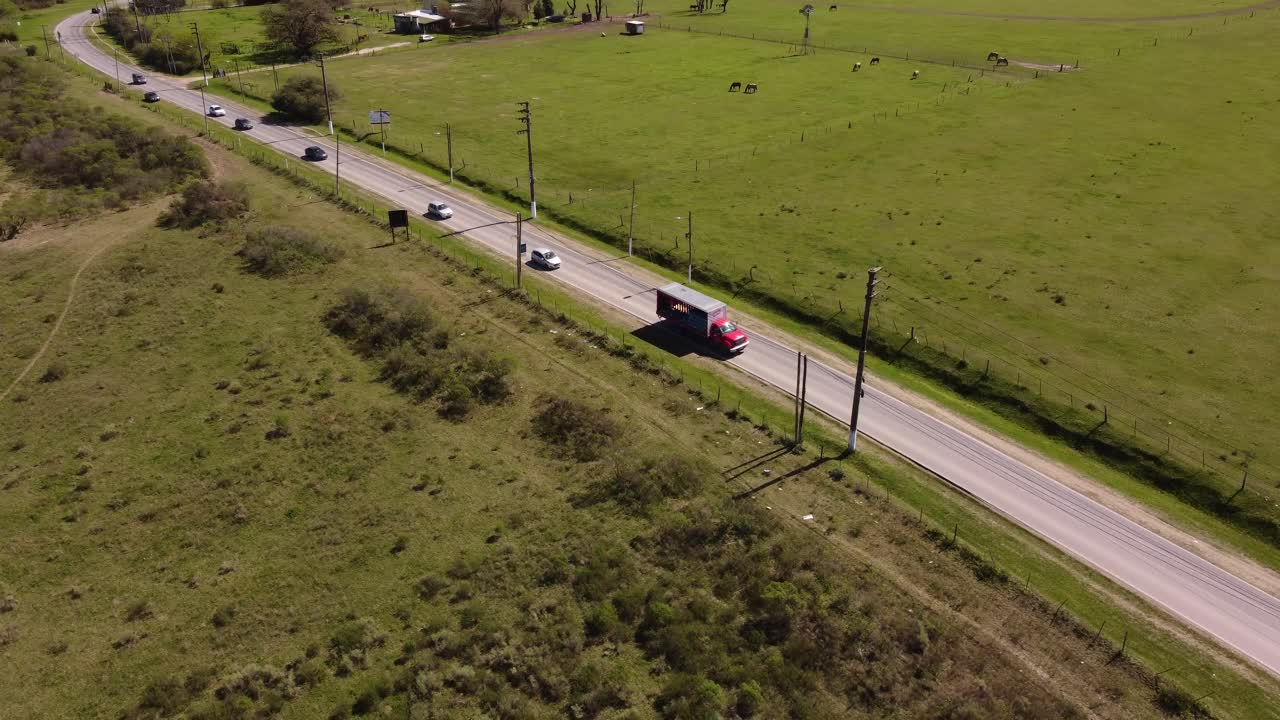 Vista aerea di un camion da carico rosso che percorre una strada in una zona rurale di Buenos Aires, Argentina
