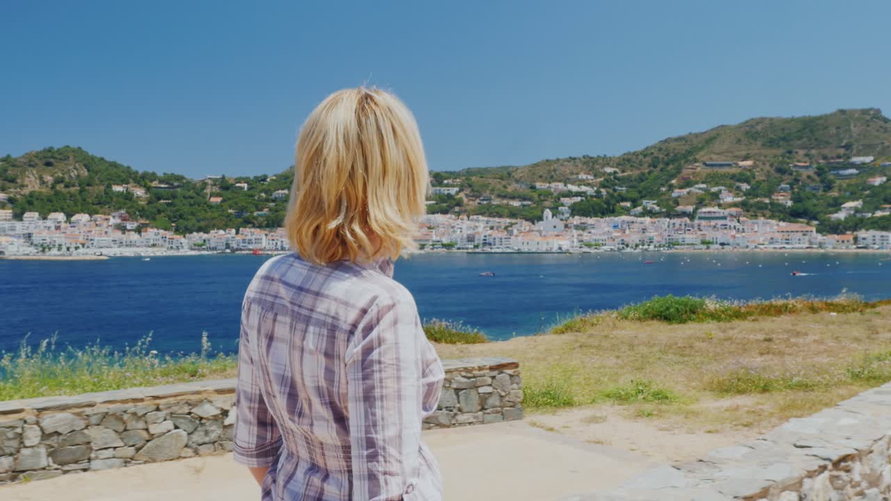 A woman rests by the sea near Cadaques in Catalonia 1