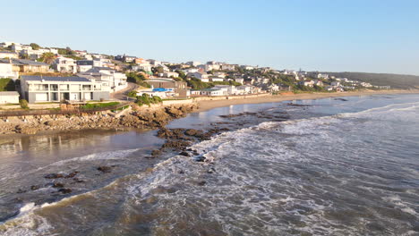 gentle waves crash onto scenic vleesbaai beach at sunrise, aerial view