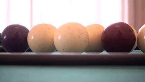 closeup slide camera of cue balls on green pool table in an ancient italian house