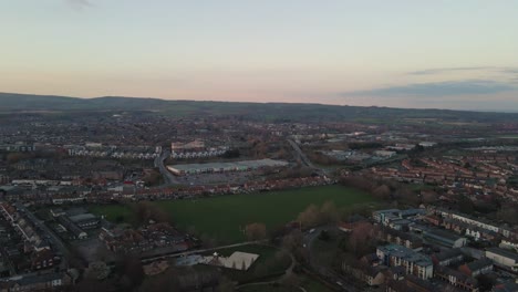 4k aerial panoramic view of  the sunset over taunton somerset, united kingdom, drone rotating to the right and showing the blue sky with some clouds. 60fps