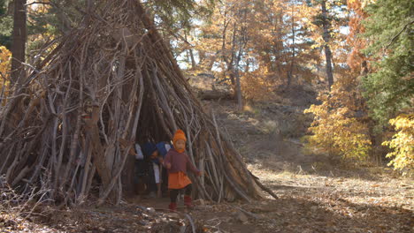 cinco niños pequeños jugando juntos dejan una cabaña en un bosque