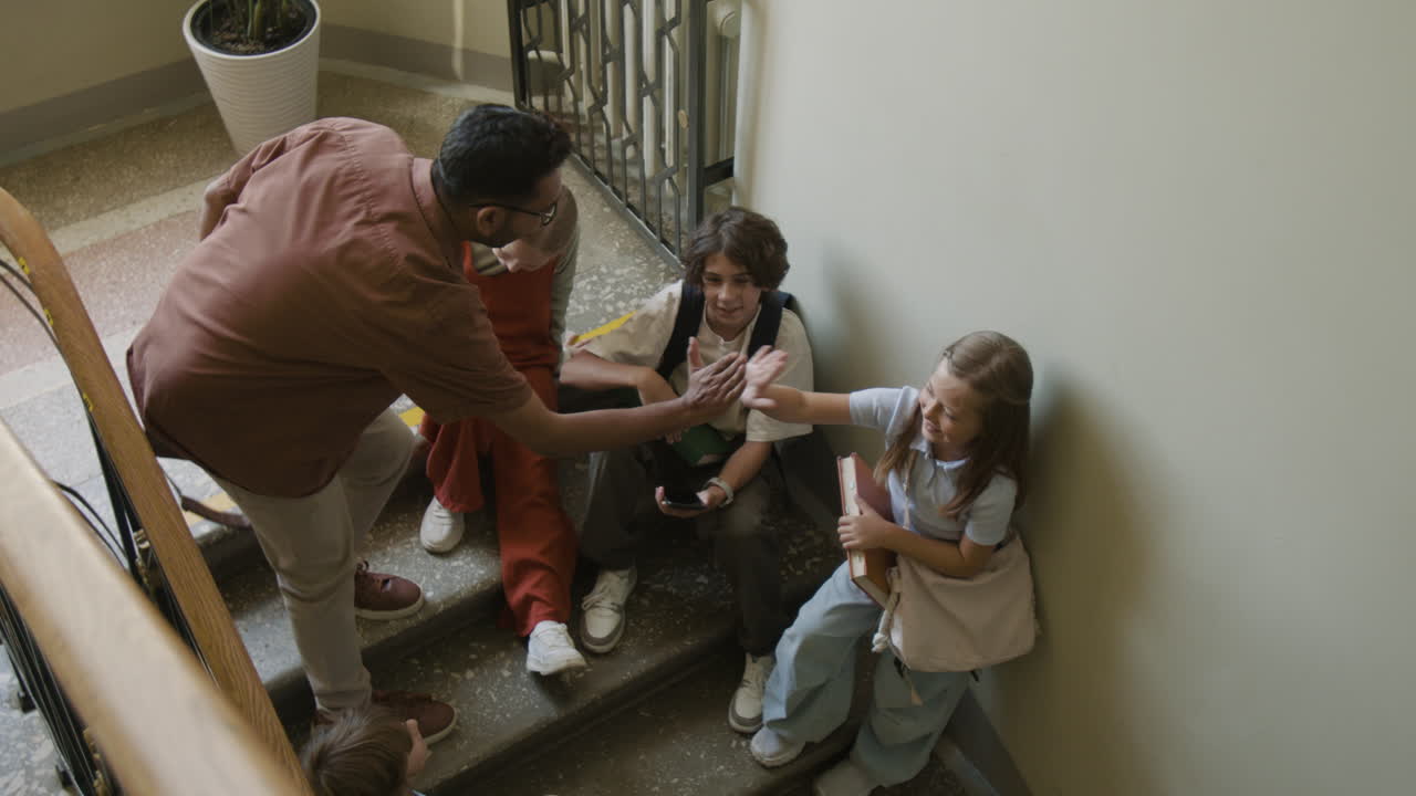 Teacher and Students Share Moments on School Stairs