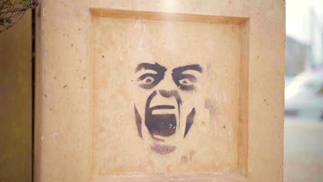 street art on a wall, graffiti of a screaming face, symbol of frustration and anger