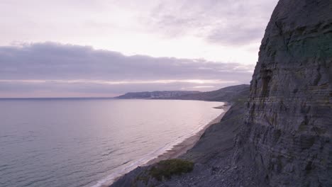 Disparo-De-Drones-Volando-Alrededor-De-Un-Acantilado-Para-Revelar-La-Playa-En-La-Costa-Jurásica,-Dorset,-Reino-Unido