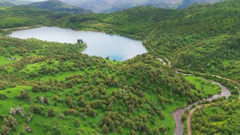 aerial view of sary chelek lake in kyrgyzstan drone fly above scenic landscape with mountains in natural reserve off road path leading to