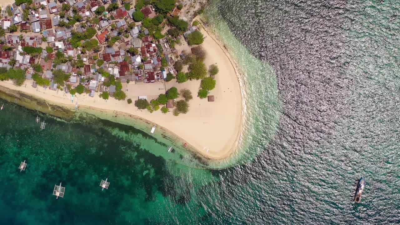 Isola di Tulang Diot nelle Filippine, vista dall'alto della spiaggia con tradizionali catamarani, ripresa aerea dall'alto che si abbassa