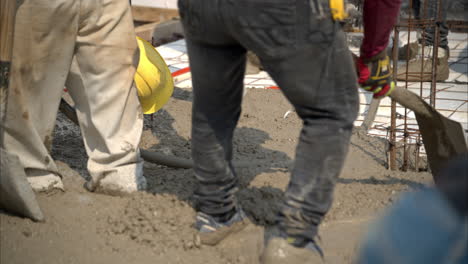 Slow-motion-of-a-construction-site-in-Mexico-with-workers-flattening-the-fresh-concrete-mix-being-poured-to-make-a-bald-on-a-sunny-day