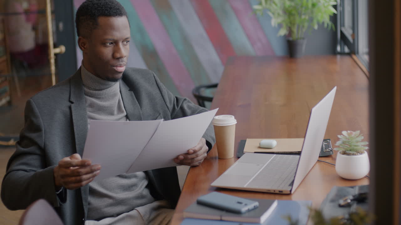 Man Reading Documents in a Cafe