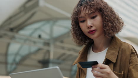 young woman paying online with credit card