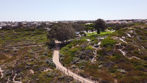 People-walking-along-a-railed-path-near-Ocean-Reef,-Perth-in-Australia