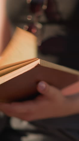primer plano de una persona sosteniendo un libro mientras las páginas se desvían rápidamente hacia la derecha debido al viento, la persona quita su mano, permitiendo que las páginas se vuelvan a desviar mientras el fondo permanece borroso
