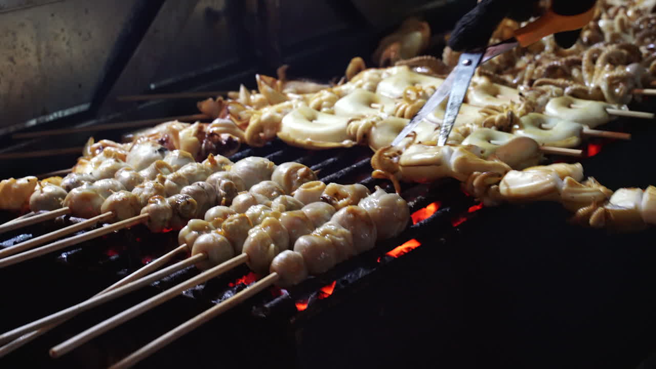 Close up clip of seafood and calamari being cooked on open grill at streetfood vendor's stall