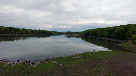 Una-Vista-De-Drones-FPV-A-Baja-Altitud-Sobre-Un-Lago-Poco-Profundo-Con-Una-Superficie-Reflectante