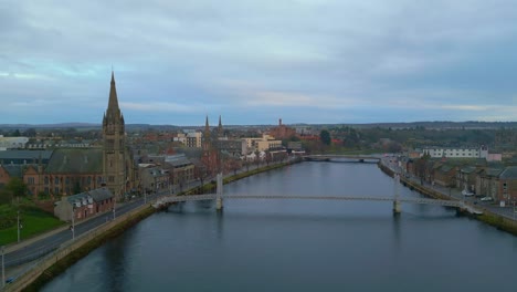 backwards fly above river flowing through historic city center