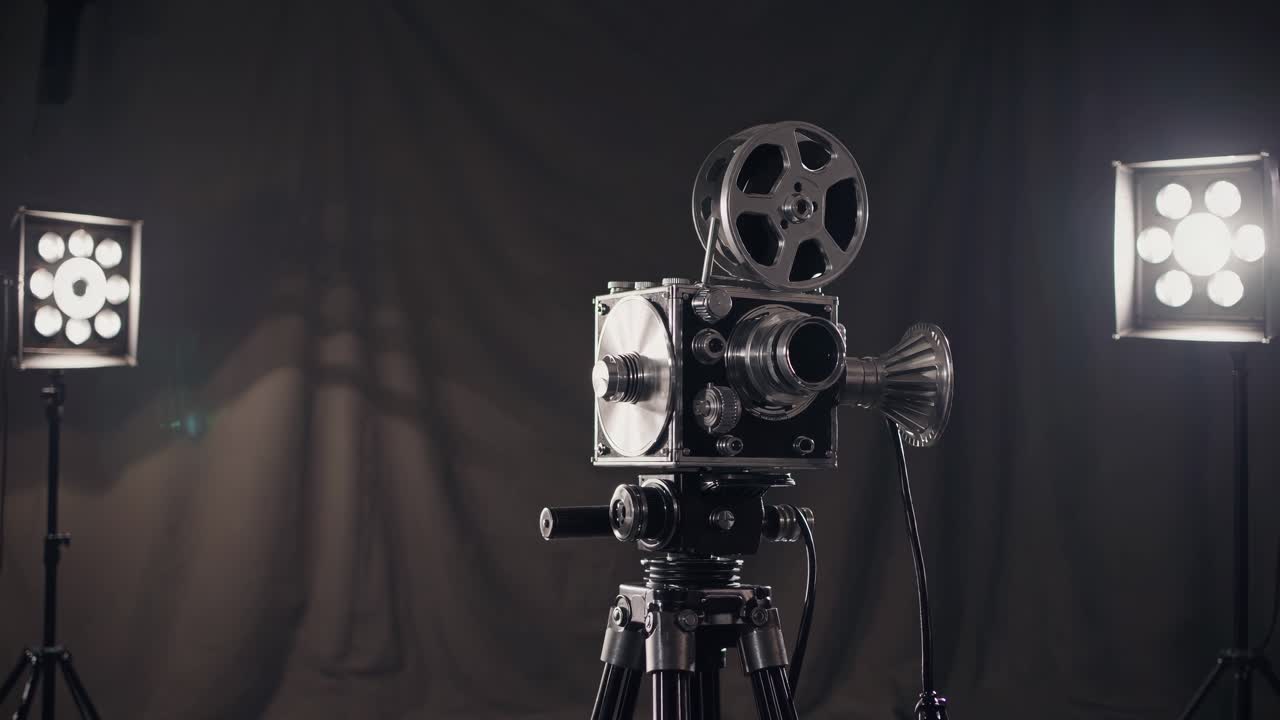 Vintage video camera on tripod, angled from the side against a dark backdrop, highlighting classic