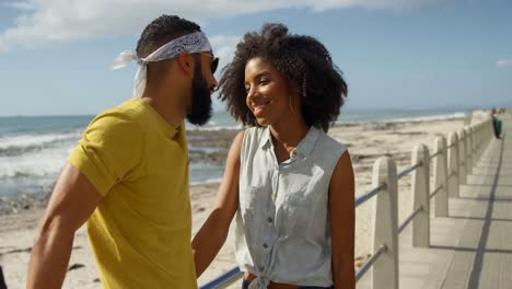 Couple-interacting-with-each-other-at-beach-4k