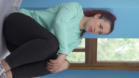 video vertical de una mujer deprimida. se sienta junto a la pared.