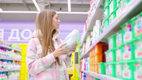mujer comprando detergente para la ropa en un supermercado
