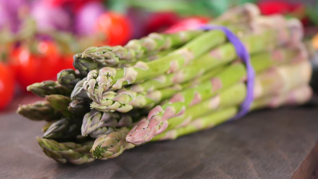 Close-up of Fresh Green Asparagus Bunch on a Wooden Board