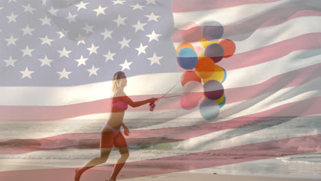 woman holding balloons in the beach and the american flag for fourth of july.