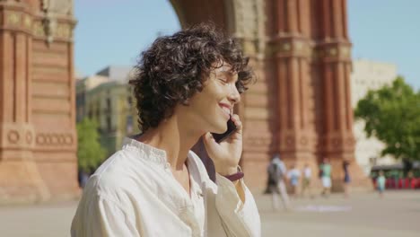 Portrait of smiling man talking mobile phone outdoor. Happy man finishing call