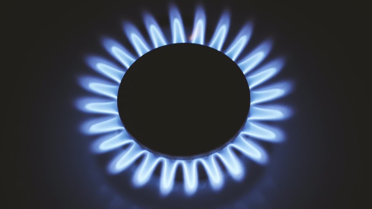 горящая газовая плита, синие пламя макро крупный план в темноте на черном фоне. 4k сырое видео с плавным движением камеры.