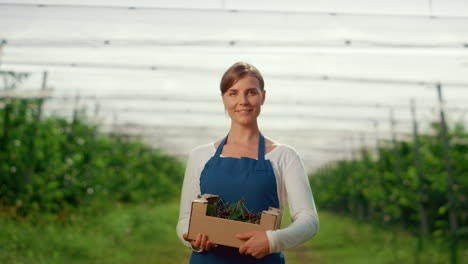 business farmer holding box with fresh fruit at summer farm in harvest season.