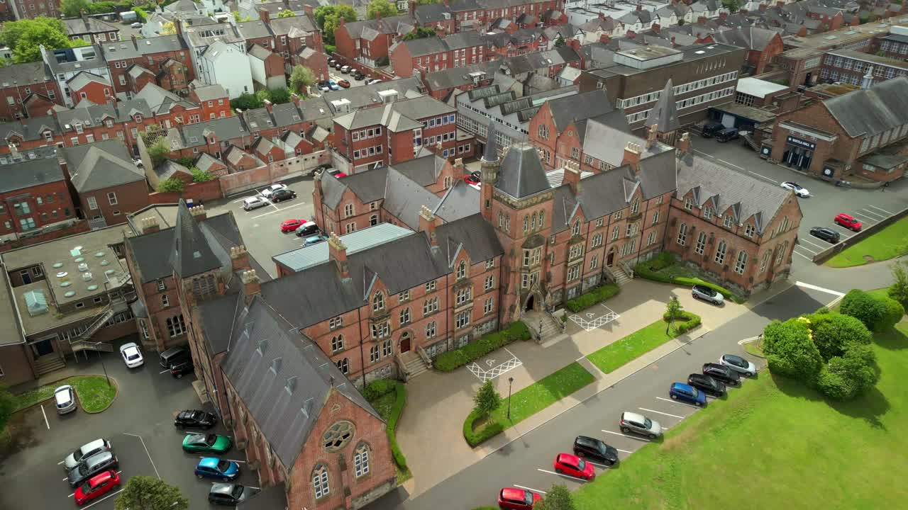 Wide ascending aerial video of Methodist College Belfast and the surrounding area in Belfast, Northern Ireland, UK on a bright and sunny day. Filmed in 4K, 60FPS and with Rec709 color.