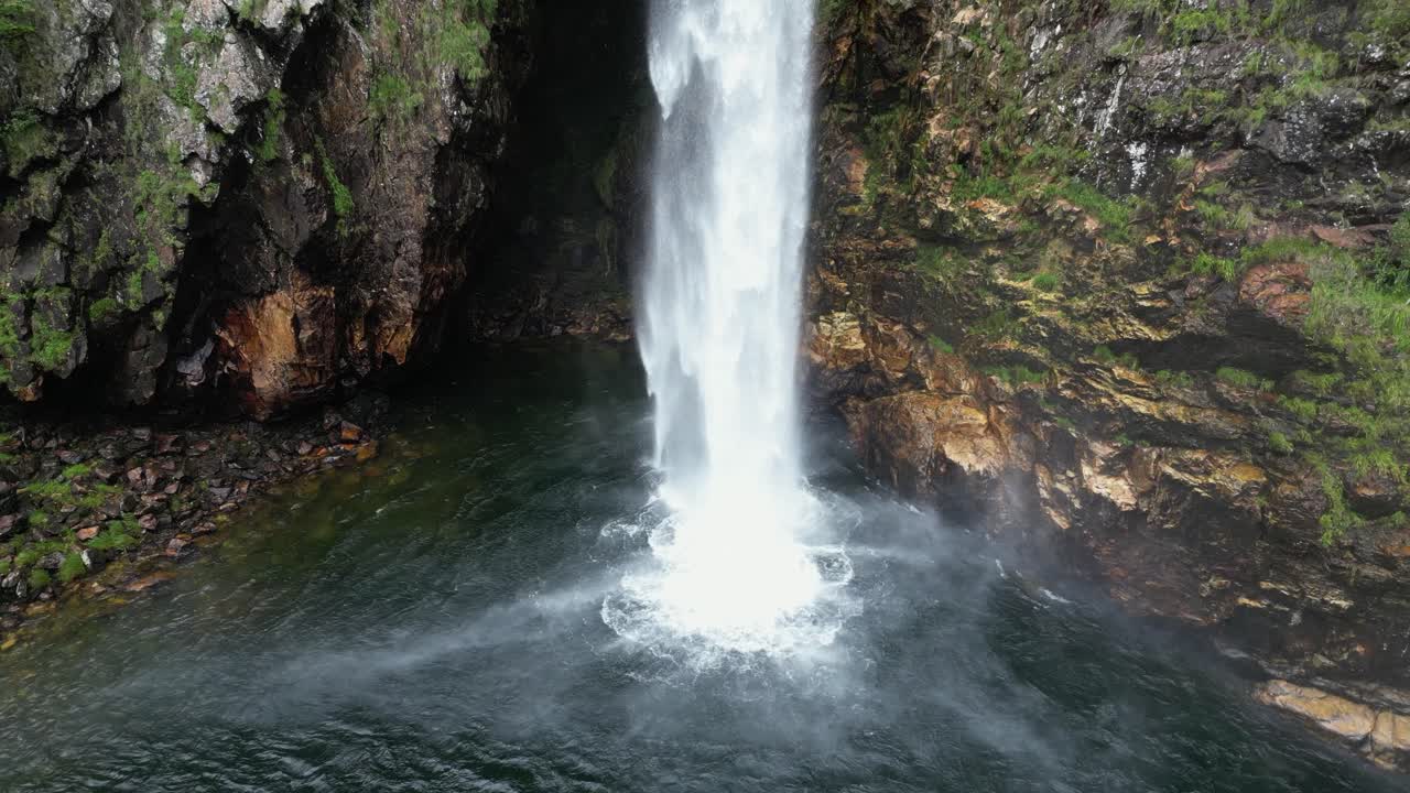 Shallow rock cavern behind freefalling Fundao waterfall in Brazil