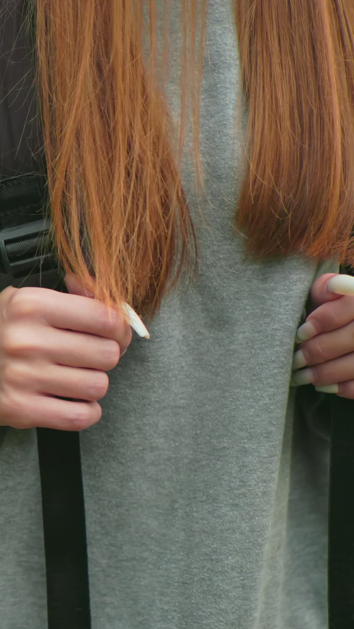 초록색 셔츠를 입은 친구와 함께 울창한 숲을 고 긴 머리카락이 어깨를 가로질러 흐르는 청바지를 입은 여성이 배 을 잡고 있는 클로즈업