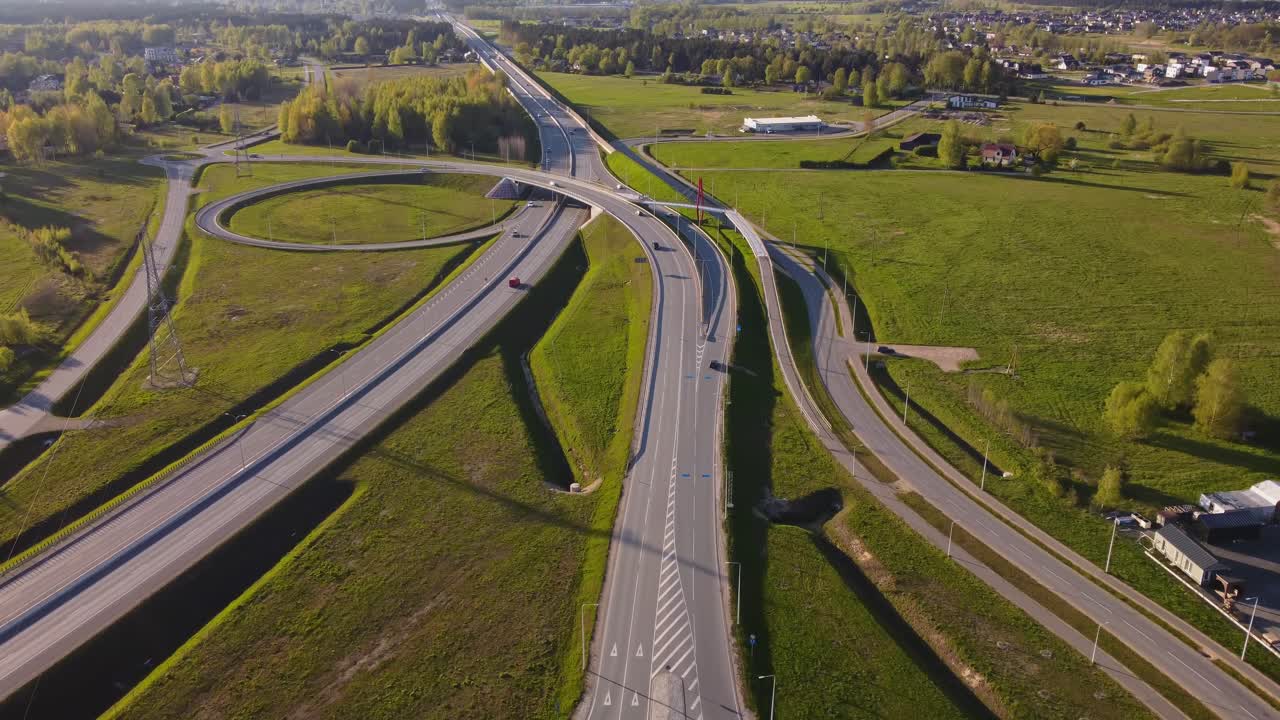 Katlakalns road interchange showing A5 Riga bypass with grade-separated ramps, slip roads, acceleration and deceleration lanes, roundabout intersection, traffic flows, aerial view, springtime