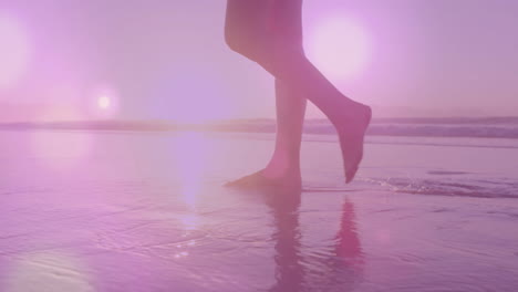 animation of light spots over biracial woman walking at beach