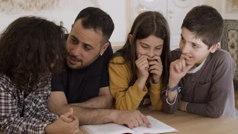 padre soltero caucásico barbudo enseñando a los niños en casa.