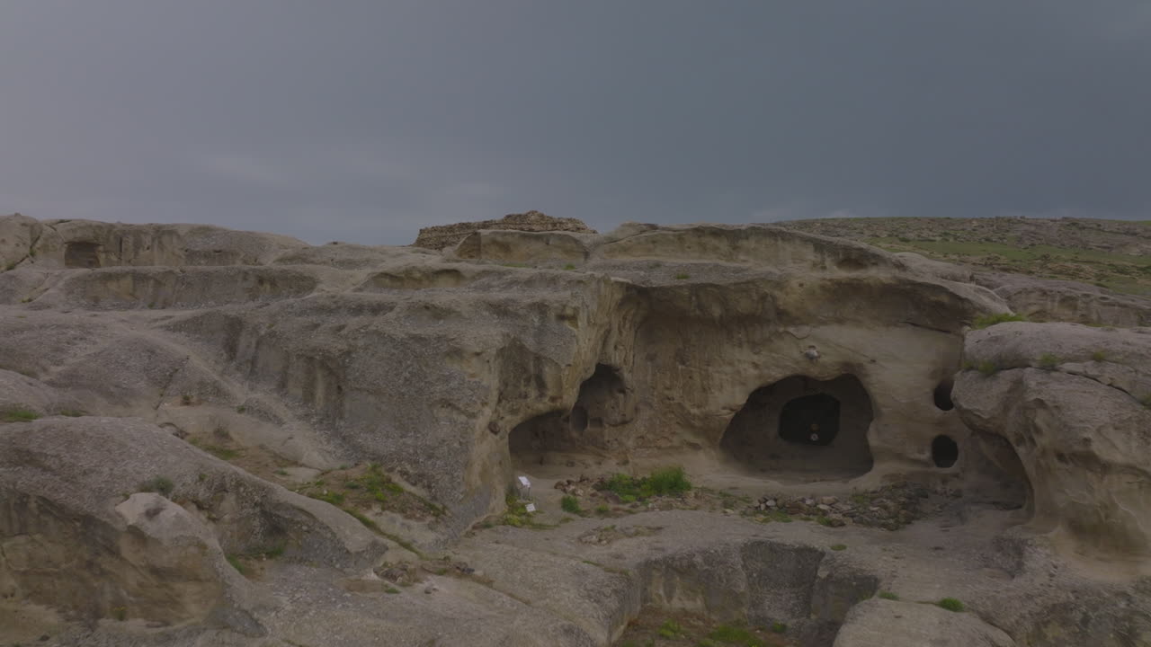 Ripresa con drone di un'antica serie di grotte formate naturalmente nella regione arida e deserta della Georgia, con rovine di una civiltà storica abbandonata