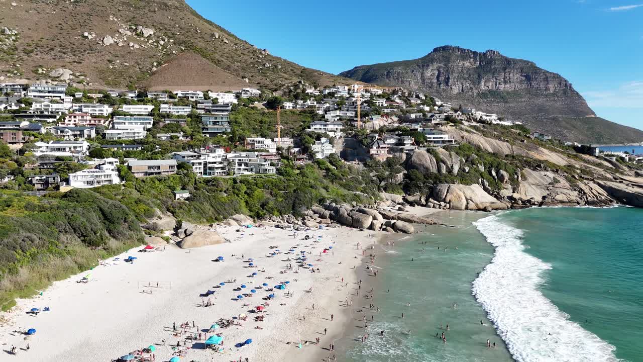 aerial footage of camps bay beach in South Africa with tourist during a sunny day of summer