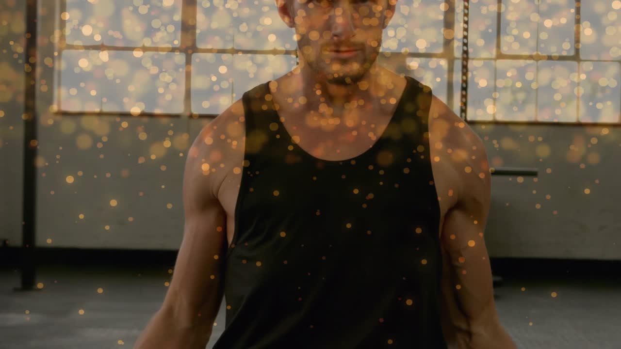 Man starting biceps curls by lifting dumbbells for gym training, golden bokeh overlay filling frame