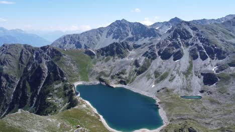 idyllic deep blue mountain lake in the middle of the swiss alps with sunny skies