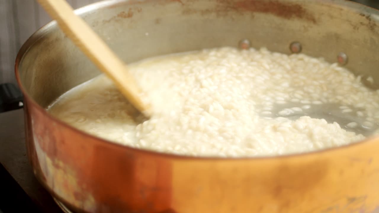 Ugjenkjennelig kokk tilbereder risotto i panne