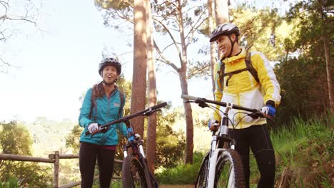 una pareja de ciclistas de montaña interactuando entre sí
