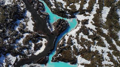 The-beautiful-blue-water-flowing-near-a-geothermal-area-in-South-West-Iceland---aerial